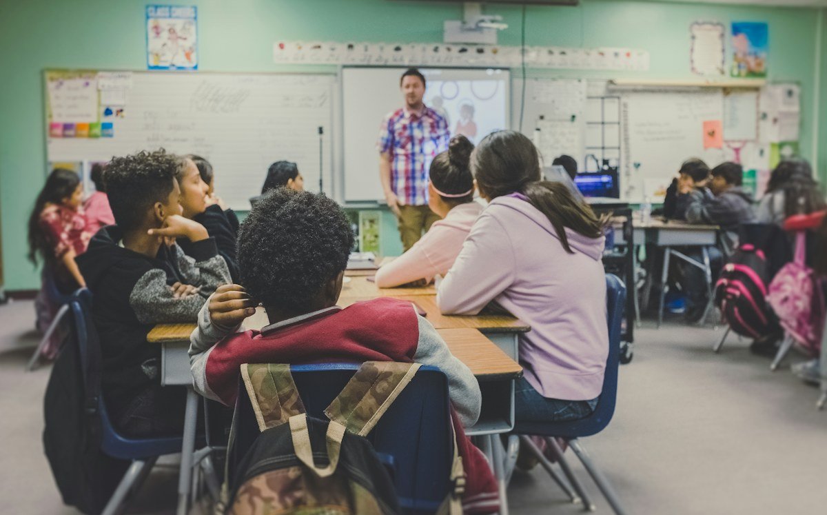 A teacher leading a classroom of students at their desks